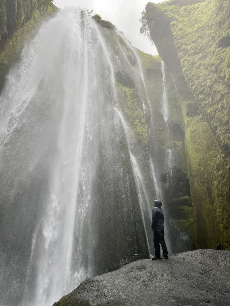 Tomasz standing in front of a waterfall